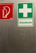 Edelstahlwand mit Schildern "Feuerl&ouml;sche" und "Verbandskasten", Foto: &copy; M. E., Pixelio