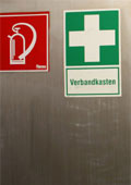 Edelstahlwand mit Schildern "Feuerl&ouml;sche" und "Verbandskasten"