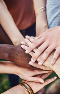 Hände von Menschen verschiedener Hautfarben aufeinander