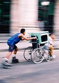 Rollstuhlfahrer wird von Inlineskater geschoben