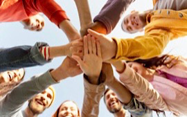 Eine Gruppe von Menschen legt die H&auml;nde aufeinander 