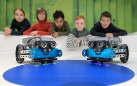 Kinder schauen auf einen kleinen Roboter