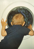 Baby schaut in die Waschmaschine