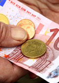 Hand hält Münzen und 10-Euro-Schein