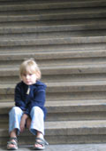 Trauriges Kind sitzt auf einer Treppe