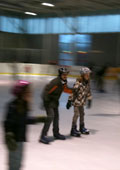 Kinder bei Schlittschuhlaufen in einer Eishalle