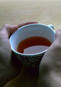 Hände umklammern eine Teetasse