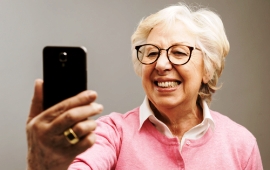 Glückliche Seniorin macht Selfies mit ihrem Smartphone