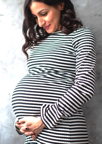 schwangere Frau schaut auf ihren Bauch