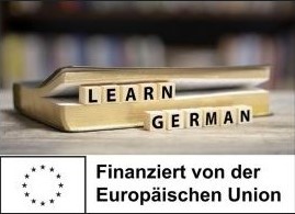 Buchstabenw&uuml;rfel mit "Lern German" vor einem Buch