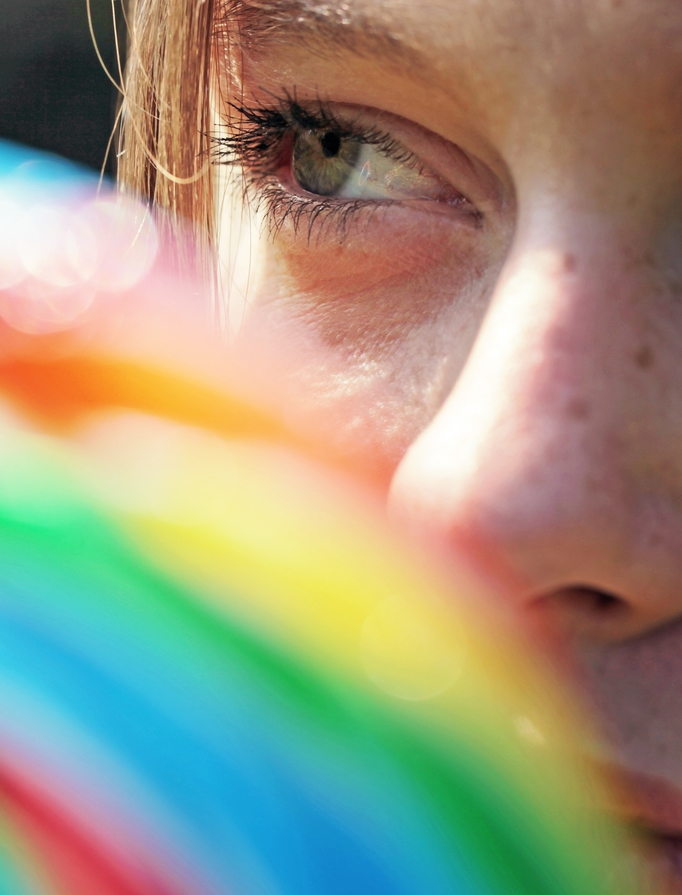 Regenbogenfarben vor Gesicht einer Frau