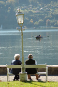 Senior/-innen auf einer Bank am See